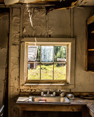 Interior of a kitchen in an old ghost town looking out to other abandoned buildings