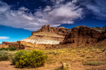 Dramatic clouds over red and white banded red rock in the desert