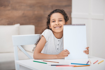 smiling african american girl showing empty drawing album