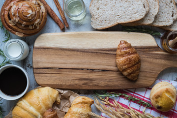 fresh bread and baked goods on wooden chopping board, rustic style