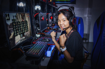 fighting young girl playing computer games in internet cafe