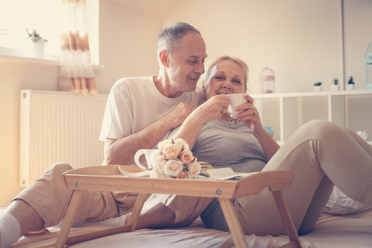 Older Couple Having Breakfast  On Bed.