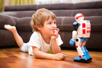 Little boy playing with robot toy at home.