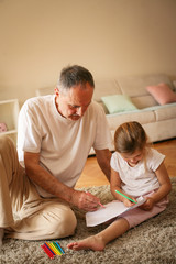 Grandfather working homework with granddaughter.