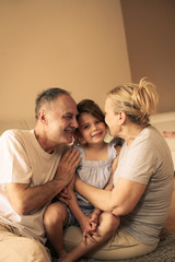Fototapeta premium Playful grandparents with their granddaughter.