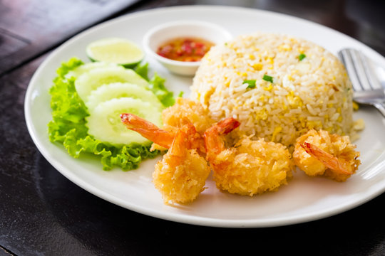 Fried rice with crispy fried shrimps dish on a wood table, Yummy meal for lunch in Thai style food.