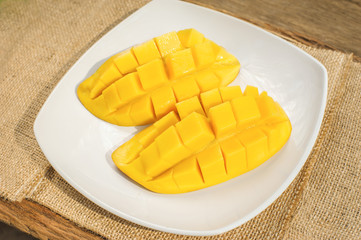 slice of fresh mango fruit put on white ceramic dish