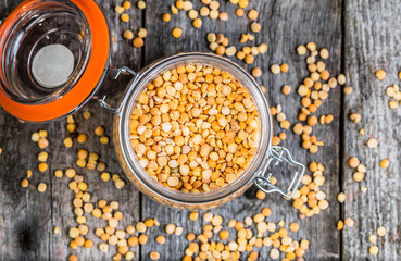 Split peas, pea in rustic jar on wooden table, healthy vegan cooking ingredients