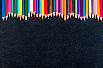 Colorful pencils on black, copy space, back to school concept