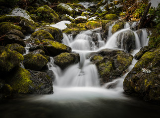 Blurred waterfall through mossy rocks
