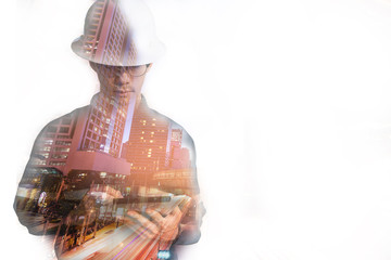 Double exposure of  Engineer or Architecture man in working shirt and safety helmet working with tablet in night building background , business and construction concept
