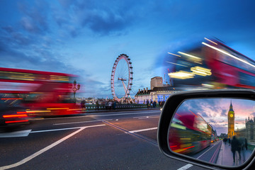 London, England - iconic red double-decker buses on the move on Westminster Bridge with Big Ben and...