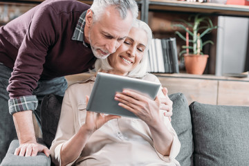 Fototapeta na wymiar happy senior couple using tablet together at home