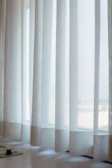 sunshire light looking pass Translucent white fabric curtains and window glass fame and view outdoor background