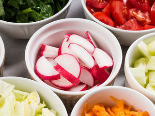 Mix of vegetable bowls for salad or snacks on gray background. Diet detox concept
