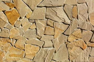 Multi-colored and multi-sized, orange and brown rock wall grunge texture background.