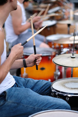 The drummer's hands with a stick behind the drum set. Baltic Drum Summit 2017. Riga, Latvia.
