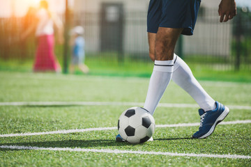 partial view of soccer player training with ball on soccer pitch