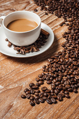 coffee cup with coffee beans,on wood table.