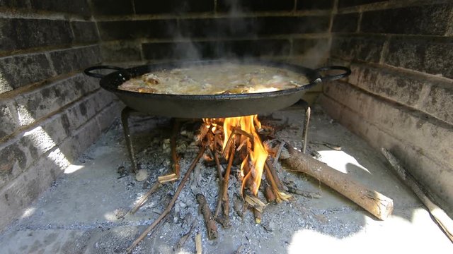 Typical and traditional spanish paella, cooking with natural fire