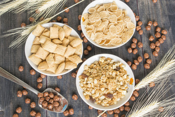 Various cold cereals on the dark wooden background.