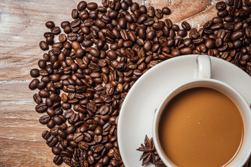 coffee cup with coffee beans,on wood table.
