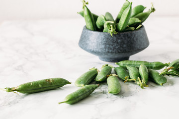 Rustic style Bowl with fresh peas on marble background