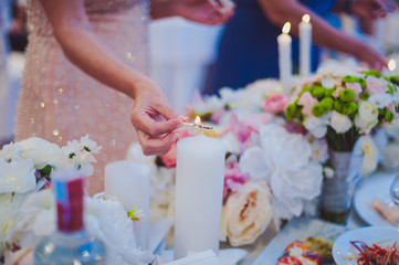 Obraz na płótnie Canvas bride and groom lighting candle