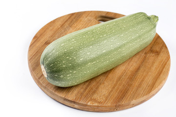 Fresh whole zucchini on the wooden kitchen board