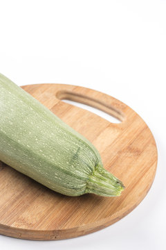 Fresh whole zucchini on the wooden kitchen board