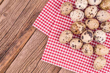 quail eggs on a red napkin on old wooden table.