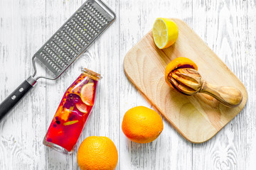 Bottle with fresh lemonade and fruits on wooden background top view