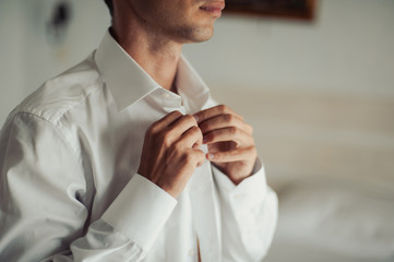 man buttoning his shirt