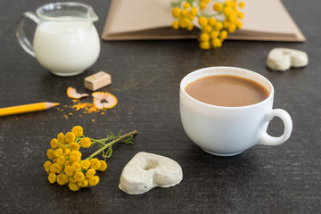 Diary with coffee, flowers and cookies on black