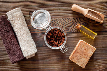 Composition of spa treatment. Coffee scrub, coffee soap, salt and oil on wooden table background top view