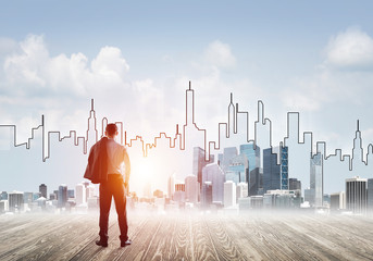 Motivation and inspiration concept with modern cityscape and businessman observing it