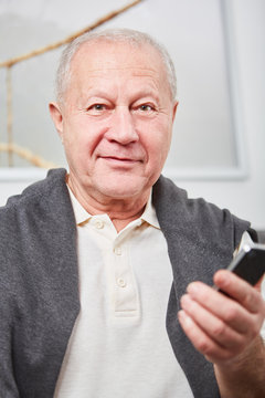 Mann als Rentner mit einem Smartphone