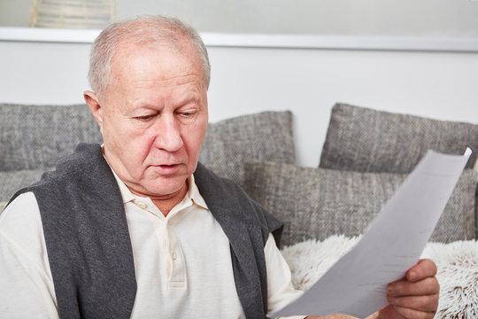 Alter Mann mit Dokument oder Rechnung