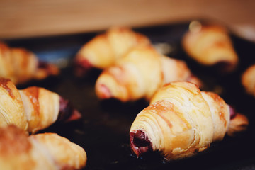 pan with fresh croissants with a sweet, cherry filling.