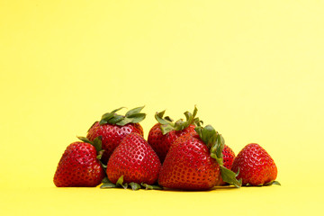 A pile of strawberries  isolated on yellow background