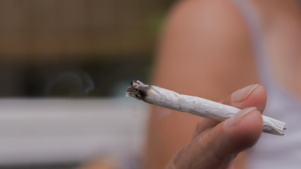 a female hand holding a selfmade/homemade cigaret 