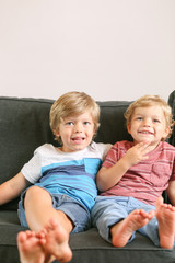 Two young brother play together on couch
