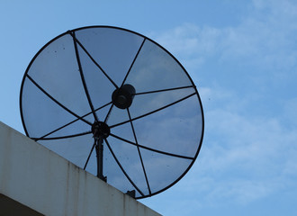 Black grille satellite dish with blue sky on roof
