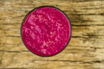 Glass of berry smoothie on rustic wooden table