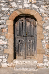 Fototapeta na wymiar old wooden door in the stone wall