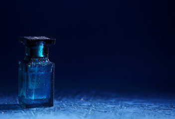 Bottle of modern male perfume on dark background