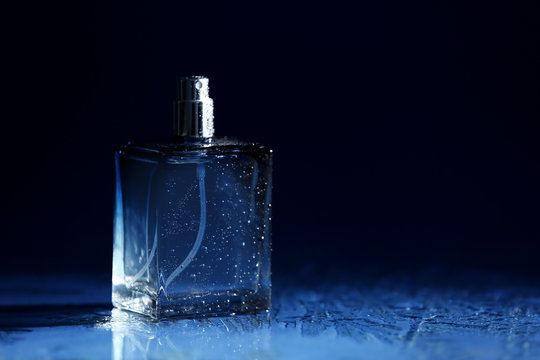 Bottle of modern male perfume on dark background