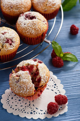 Sweet homemade raspberry muffins on wooden table.