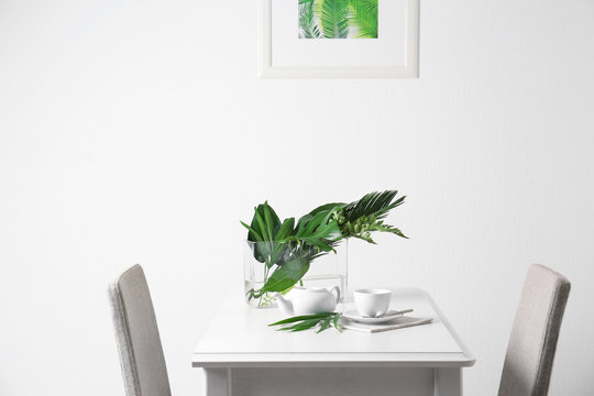 Table setting with green tropical leaves in cafe
