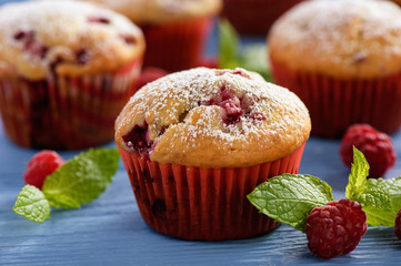 Sweet homemade raspberry muffins on wooden table.